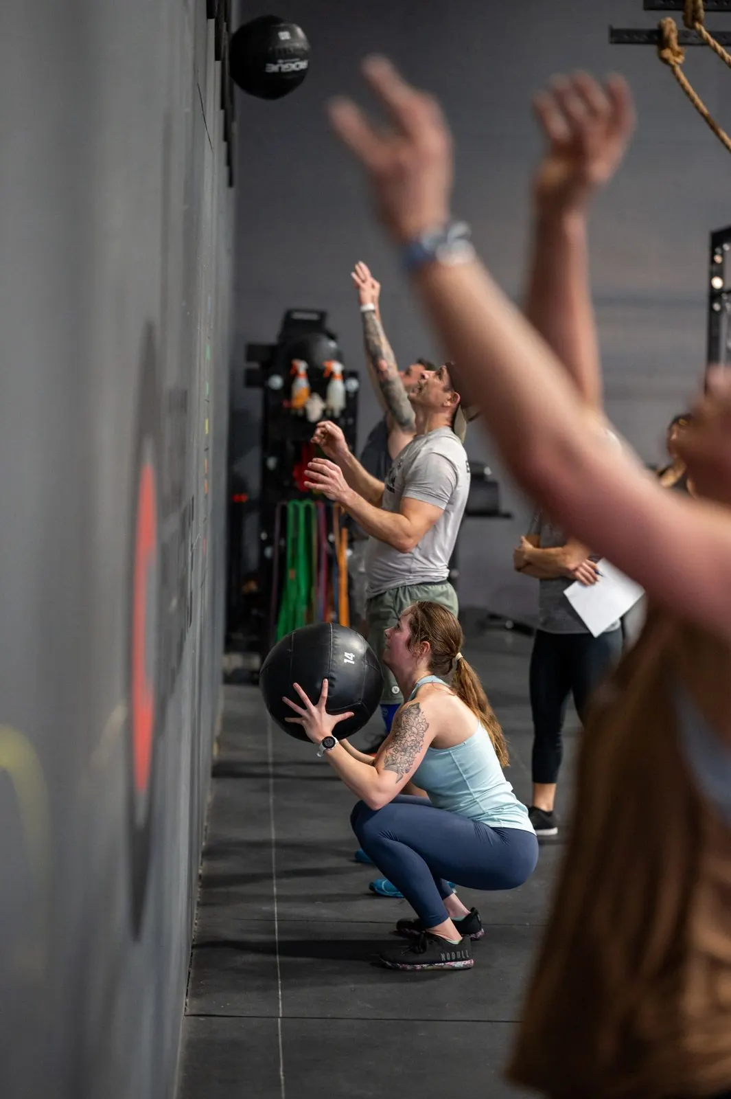 A line of members throwing wall balls together