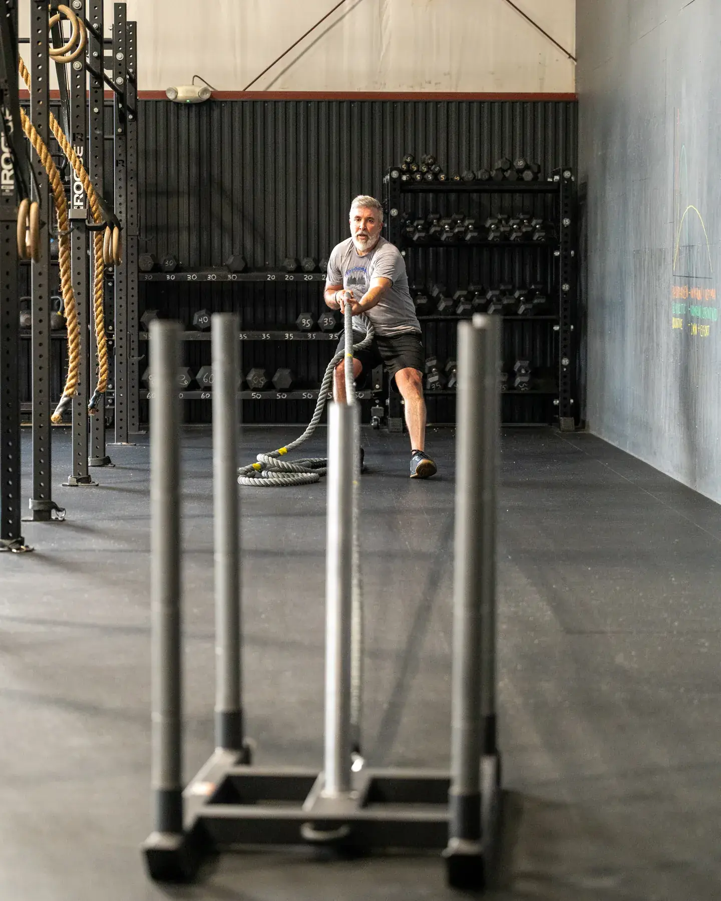 A member pulling a weighted sled in with a rope during a Hyrox class