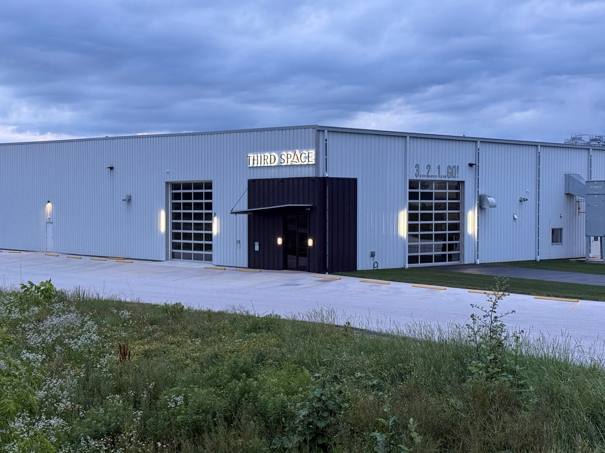 The Third Space building at dusk on County Road C, with its lit sign above the entrance